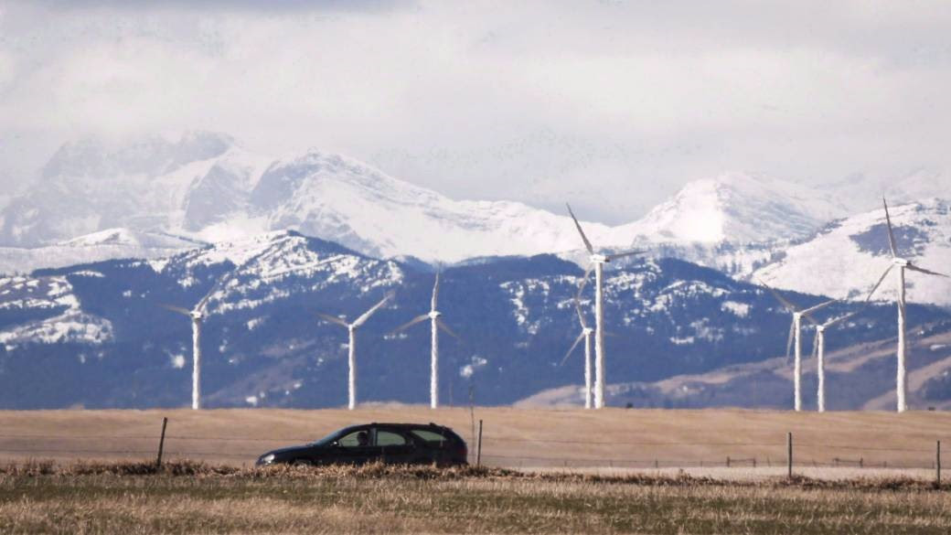 car driving against mountain background with wind turbines